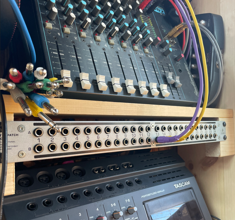 Modular synthesizer setup with patching cables in a dark studio